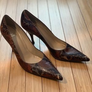 Stuart Weitzman pointed toe snake pumps.